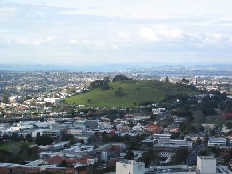 Der Blick vom Mount Eden auf Auckland zeigt, dass die Stadt auf Vulkanen erbaut ist und ueberall noch die ueberwucherten Krater zu sehen sind.
Vue du Mt Eden sur la ville de Auckland et ses volcans parsemes dans la ville