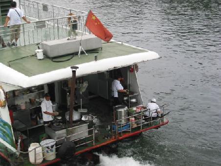 Blick in die Kueche auf der Bootsfahrt auf dem Li River
Cuisine au grand air a bord du bateau sur la riviere Li