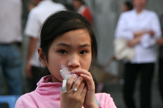 Ein kleines Maedchen huetet sein gerade erhaltenes Osterei.