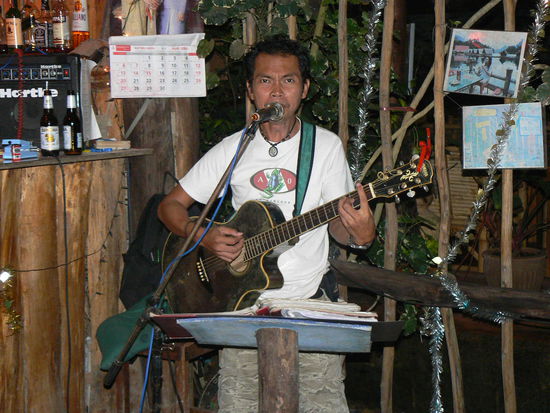 Er stand schon vor zwei Jahren an der gleichen Stelle im Lazy House und trinkt sein Singha mit dem Strohalm.