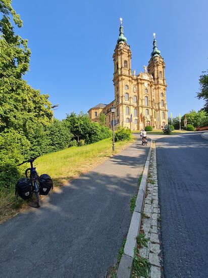 Nach dem substanzraubenden Anstieg (lt. Radlerportal "quaeldich.de" 14,5 % im Schlussanstieg von Lichtenfels-Grundfeld aus), folgen noch 8 unkommentierte Bilder vom Inneren der Basilika Vierzehnheiligen.
Die Vorgeschichte dieses Prunkbaus beginnt in etwa der Mitte des 14. Jahrhunderts, als ein Schäfer Erscheinungen des Jesukindes und einer Kinderschar, den 14 Nothelfern hatte und bald darauf eine Kapelle an dem Ort gebaut wurde.
Das auf 390 m Höhe gelegene Franziskanerkloster mit den 75 m hohen Türmen wurde dann 1744/45 im Stile des Rokoko erbaut.
Heute leben dort sechs im Konvent lebende Klosterbrüder.
Zahlenmäßig kann man von 500.000 bis 800.000 Besuchern jährlich ausgehen.
