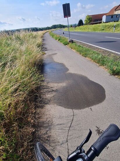 Um 9:20 Uhr erscheint doch tatsächlich noch der letzte feucht-nasse Überrest des so frühmorgendlichen Gewittertreibens. Am Glänzen der Reifenlauffläche und der schmalen, feuchten Spur sieht man, daß ich nach "Reifenkühlung" etwas zurückschob.