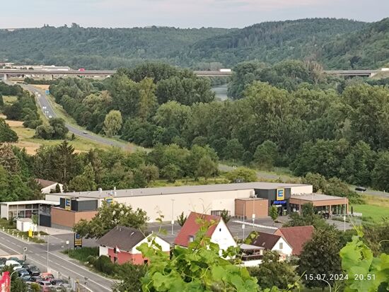 Leicht oberhalb der Bildmitte nähert sich der Main aus dem Hintergrund in einer Biegung an.