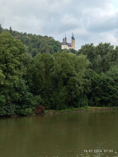 Inzwischen bereits auf dem Gebiet der Residenzstadt Würzburg angekommen, erscheint linksmainisch auf der Anhöhe das Marien-Heiligtum Käppele.