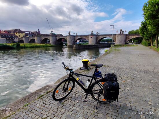 Blick zurück flußaufwärts zur Alten Mainbrücke. 
Zwischen den rechten beiden Brückenpfeilern verläuft die Schleuse Würzburg.