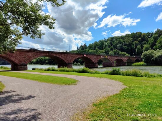Zurück von politischen zu baulichen Künsten:
Nach Neustadt am Main, Rothenfels und Hafenlohr erscheint ca. 20 km mainabwärts von Lohr a. Main die Alte Mainbrücke von Marktheidenfeld, die viertälteste Brücke am bayerischen Main. die am 29. Januar 1846 (also genau 118 Jahre vor meinem Erscheinen   ) eröffnet wurde. Sie hat die Konstruktion einer Bogenbrücke aus rotem Main-Sandstein bei einer Gesamtlänge von 190,4 m, 10 m Breite und einer längsten Stützweite von 27,2 m.