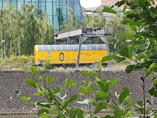 Es handelt sich um einen knallgelben gedeckten Güterwagen, wie er früher zum Transport von Bananen verwendet wurde und direkt vor der EZB an den früheren Güterbahnhof und die Großmarkthalle hier in Frankfurt Ost erinnern soll.
Als Restaurationskosten für den historischen Güterwagen sollen € 40.000 investiert worden sein.