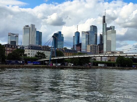 Von rechts: Der Commerzbank-Tower mit 259 m (incl. Spitze 300 m) Höhe höchstes Hochhaus Deutschlands und der EU. Dann folgt der Taunus Turm mit 170 m Höhe.
Weiterhin der MAIN TOWER, eingeweiht in 2000. Mit 200 m Höhe (mit 240 m) vierthöchstes Hochhaus Deutschlands und Rundfunkstudio des HR.
In Bildmitte der Gallileo (das Doppel-l ist eine bewußte Bezeichnung).
Bis 2008 diente es als Zentrale der Dresdner Bank, bis diese von der Commerzbank übernommen wurde.
Zweiter von links: Der 1978 eröffnete und 166,3 m hohe Silberturm wurde nach einer Nutzung von 2012 bis 2020 durch die Deutsche Bahn und deren Dienstleister DB Systel an ein Wiener Unternehmen verkauft.
Ganz links: Das Trianon aus dem Jahre 1993 und 186 m Höhe ist der Hauptsitz der Deka-Bank (Wertpapierhaus der Sparkassen-Finanzgruppe).
