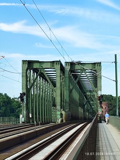 Der nur an der Brückennordseite angebrachte Fußgänger- und Radlersteg wurde in einer Beschreibung als recht schmal bezeichnet, so daß sich begegnende Radler und Fußgänger schon mal verbal gezankt haben sollten.
Zum einen war während meiner Stegnutzung kaum (Gegen-)Verkehr, andererseits gab es mit einem begegnenden Radler ein freundliches Lächeln mit einem
"Servus und Habe die Ehre" und mit angepasster Geschwindigkeit passierte man einander. Es kommt halt immer auf die einzelnen Individuen an, die mit ihrer Rücksicht aufeinander ein problemloses Miteinander ermöglichen. Wenn ich dagegen an so manche "Radl-Rowdys" denke, die sich besonders am Frankfurter Mainquai auf ihren urbanen Speed-Rädern gerade noch im letzten Moment mit einem Affenzahn zwischen zwei sich begegnenden Radlern durchzwängen müssen, muß man sich keinesfalls wundern, wenn es immer wieder mal kracht ! Dies will ich mal gesagt haben !