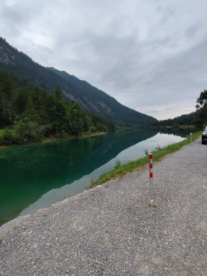 Vom Hintergrund bis hierher verjüngt sich der Kleine Plansee, auch der grüne Eindruck des Wassers verliert sich durch den veränderten Blickwinkel.
Hier gleich links anschließend (leider nicht aus der Nähe fotografiert) befindet sich die Seespitzbrücke, ein Fußwanderer und Radlersteg, der an der Engstelle vom Kleinen Plansee zum Plansee die Weiterfahrt zum Heiterwanger See ermöglicht.