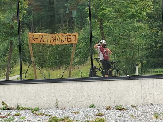 Dann hier im Bild die Vorstufe des optischen Schocks, noch auf Tiroler Gebiet.
Nicht wegen der spiegelverkehrten Bilddarstellung des Biergartenschildes in einer Fensterfront.
