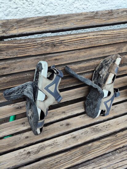 Anderntags zuhause meine "schloaßigen" (verschlissenen) Click-Sandalen, deren lösgelöste Sohlenteile ich zu einem späteren Zeitpunkt behelfsweise bis zu einer noch nicht erfolgten Ersatzbeschaffung mit mehreren Kabelbindern wieder fixierte.
Ist schon irgendwie amüsant, daß beide Click-Sandalen am gleichen Tag
"aus dem Leim" gingen.
In 2008 hatten sie mich bereits das erstemal per Rad-Einsatz auf großer Tour von Paris nach Hause begleitet und in späteren Jahren auf mehreren Ferntouren eine gute und fußfreundliche Verbindung vom Fuß zum Pedal dargeboten.
Museumsverdächtig !