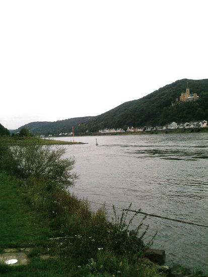 Von links her mündet die Lahn an der grünen Landzunge in den Rhein. Rechts oben an der Anhöhe des linken Rheinufers das im vorigen Bild bereits beschriebene Schloss Stolzenfels kurz vor Koblenz.