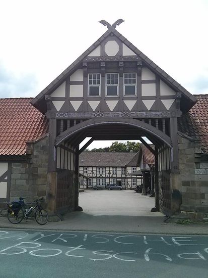 Die komplette Einfahrt zum Innenhof. Da der vermutliche Besitzer gerade ins im Hintergrund befindliche Auto einstieg, fuhr ich von der Neugier getrieben zu ihm hin und fragte, ob hierher aus dem Bayernlande eingeheiratet worden sei. Er erklärte mir dann, daß er in Bayern mehrere Freunde habe und ihm seine hiesigen Freunde/Nachbarn deswegen diesen Streich gespielt hätten. Übrigens habe ich ihn noch mit Excellenz angeredet und wir konnten das Lachen nicht ganz zurückhalten.