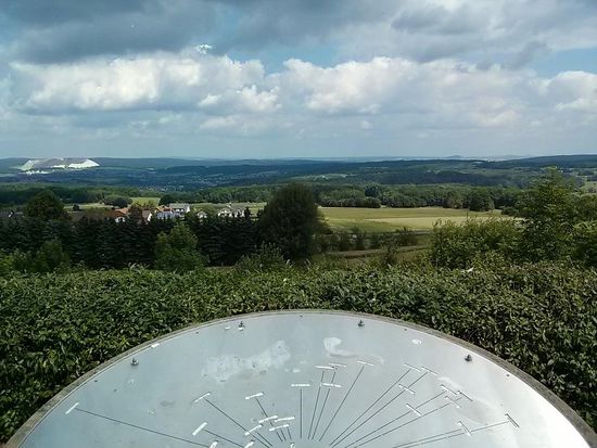 ...und vom "Eichenrieder Weitblick" im Naturpark Hessische Rhön wirkt er links im Hintergrund nur noch wie ein Häufchen Salz, das gerade mal ein gestrichenes Teelöffelchen ausfüllen könnte. Im Vordergrund die Orientierungstafel mit den markanten Geländepunkten.