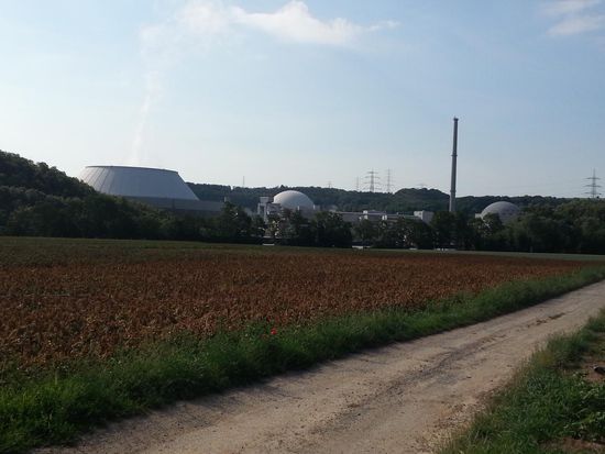 Technischer Zwischeneinwurf:
Das Atomkraftwerk Neckarwestheim, von dem ein Reaktor noch in Betrieb ist. In der Mitte des recht niedrigen Kühlturms links sieht man etwas verdunstetes Kühlwasser als schmalen Wolkenschlauch austreten.