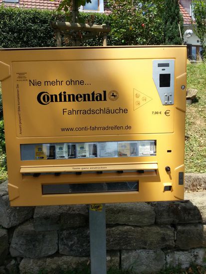 Schleichwerbung hin, dasselbe nochmal her: Falls der Pannenteufel an der hoffentlich richtigen Stelle zuschlägt, sich kein Ersatz bzw. Flickzeug in der Packtasche befinden sollte oder dieser durch eine Pechsträhne aufgebraucht sein sollte und Geschäfte geschlossen sein sollten:
Dies war der einzige Schlauchautomat, dem ich direkt zwischen Frankfurt - Stuttgart - Neu-Ulm begegnet bin. Es gibt aber auch Smartphone-Apps, die einem den Weg zu diesen Spendern weisen können. Ich hatte übrigens zwei Reserveschläuche (Achtung, ausgleichende Schleichwerbung) der Marke mit einem Vogel, der gerne in Kuhställen nistet bzw. des Begriffs, der umgangssprachlich in etwa der vorausgegangenen Aktion eines nicht berechtigten Elfmeters entspricht...
Übrigens war ich die ganze Ferntour komplett pannenfrei. Weder die Kettenluft ging aus, noch gab es anderweitige technische Miesmacher !
Das wünsche ich auch meinen anderen Hobby-Kollegen, egal welche Entfernungen sie zurücklegen !!!
Schlussfazit zum Foto bzgl. der früheren Ware in diesen Automaten:
Kippen raus - Radlschläuche rein !!!!!!!!!!  