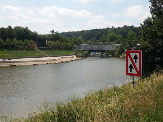 Unter dieser architektonisch gelungenen Radler- und Fußgängerbrücke mündet die Rems bei Remseck in den Neckar, der von der rechten Seite her fließt, hier aber unglücklich vom Schifffahrtszeichen und Gebüsch verdeckt ist.