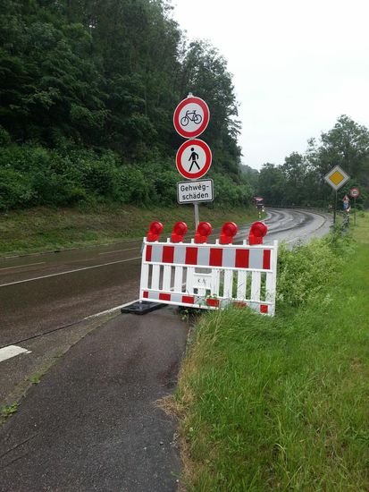 Etwas nach Geislingen auf Höhe der Straub Mühle ein kleiner Schockmoment: Soll ich etwa bei schlechtem Wetter auf der viel befahrenen B10 hochstrampeln?
Glücklicherweise kam mir von rechts her ein Kunde aus Richtung der Mühle entgegen, der mich auf einen Kiesweg aufmerksam machte, der unterhalb des Hanges rechts der Straße bis zum Ende des gesperrten Rad- und Fußgängerwegs führte.