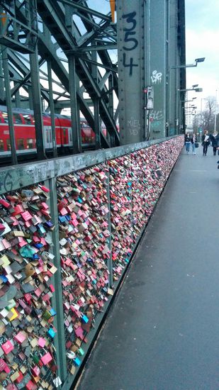 ...die zu abertausenden die gesamte Brückenlänge (&gt; 400m) entlang an der Abgrenzung zu den sechs Schienensträngen der Eisenbahn behängen.