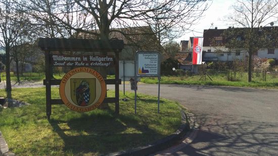 Nochmals ein wenig weiter weiß-blaues Rautenmuster im Gemeindewappen und rechter Hand im Hintergrund nochmals eine spezielle sportliche "Huldigungsfahne".
Mein Gedanke war:
So fern von zu Hause und dennoch "wia dahoam"