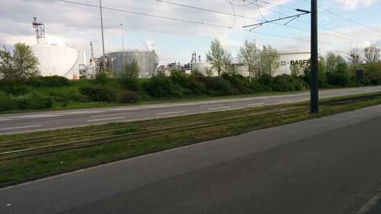 Nachdem auch Frankenthal durchquert wurde, finde ich mich inzwischen auf Ludwigshafener Stadtgebiet wieder. Zur Linken geht's an einem kleinen Teil der ausgedehnten Anlagen eines "örtlichen Anilin- und Soda-Kochers" (von der Aufschrift auf einem der Großtanks mal abgesehen, möchte ich von weiterer Schleichwerbung Abstand nehmen...)