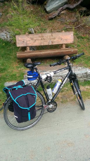 Für mich ging es ab St. Moritz gleich größtenteils auf einem Naturweg weiter zur Ortschaft Maloja, wo ich vorgebucht hatte. Nach der "strapaziösen" Bahn- und einigen wenigen km Radfahrt hätte ich normalerweise gerne eine Rast auf dieser massiven und von "Aldo" und seiner Familie privat gesponserten Bank eingelegt, aber mit einer Stunde Verspätung und da immer wieder, wenn auch nur ganz leichter Nieselregen einsetzte, rollte ich doch gleich die insgesamt gut 20 km gegenüber den 16 km nur auf der normalen Straße weiter zum Tagesziel Maloja.