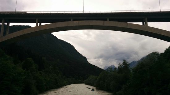 Blick von der kleinen Innbrücke beim Bahnhof Imst-Pitztal auf die große Brücke der Pitztal Landesstraße. Auf der rechten Seite sind vier Rafting-Schlauchboote im Annähern.
Wenn man den Blick zurück nach Westen richtet, merkt man schon eine unleidige Wolkenverdichtung bzw. -vergrauung, aber noch bestand kein Regenalarm...