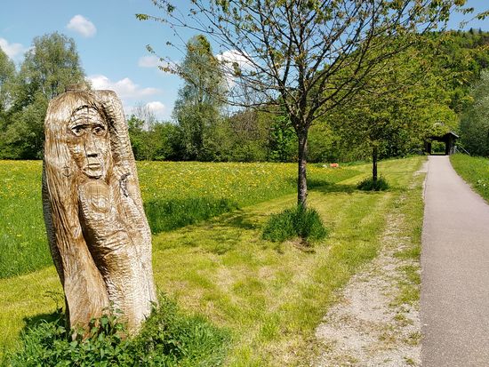 Kurz nach der Schenkenbergbrücke erscheinen zwei mannshohe Holzschnitzereien