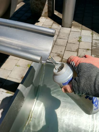 Auffüllen der Trinkwasserflaschen an der Spenderrinne des Wasserwerks Neckarburg.
