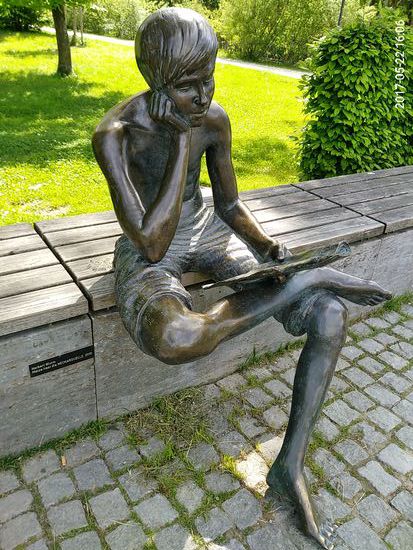 Auf der Inschrift steht: 
Matze liest die NECKARQUELLE
Bei der NECKARQUELLE handelt es sich um eine Zeitungsausgabe