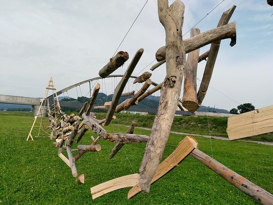 Interessant sind immer wieder entlang des Radweges postierte Kunstgegenstände, wie etwa diese Art von Holzxylophon in Form von an Schnüren aufgehängter Holzprügeln, die, wenn man das Gebilde genügend in Schwingung bringt, interessante "rustikale" Tonversionen hervorbringen.