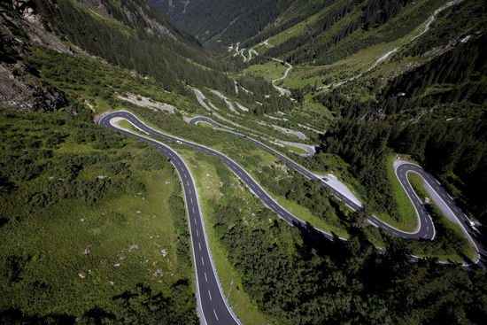 Ein besonderer Hinweis zu diesem Bild:
Es stammt nicht von mir selbst, sondern wurde mit freundlicher Genehmigung der
Golm Silvretta Lünersee Tourismus GmbH, Achim Mende
für die Anzeige in meinem Reisebericht freigegeben.
Vielen Dank an meine Ansprechpartnerin Sarah, sowie auch dem professionellen Fotografen Achim Mende, der weltweit faszinierende Traumlandschaften in atemberaubenden Luftbildern mit seiner hochtechnisierten Kameraausrüstung festhält.
Da ich mit meinem Fahrrad natürlich nicht in die Luft gehen konnte und meine vorangegangenen, mit der simplen Handy-Fotofunktion getätigten Aufnahmen nur kleine Fragmente des serpentinenartigen Straßenverlaufs aus der Tallage herauf bis kurz vor dem Vermuntstausee zum Augenschein bringen konnten, habe ich mich dafür entschieden, dieses Fremdfoto nach vorangegangener Genehmigung in meinen Reisebericht einzubinden. Besonders bei diesem Bild verstärkt die Vergrößerungsfunktion in der rechten oberen Bildecke den visuellen Eindruck ganz bedeutend.
Kleine Ergänzung: Von der hell erkennbaren Parkplatzausbuchtung in etwa Bildmitte leicht rechts wurde z.B. das vorhergehende Bild mit mir am Rad gegen den Hintergrund in Richtung Tal von einer netten Familie, die ihrem Kfz eine kleine Pause gönnte, aufgenommen.