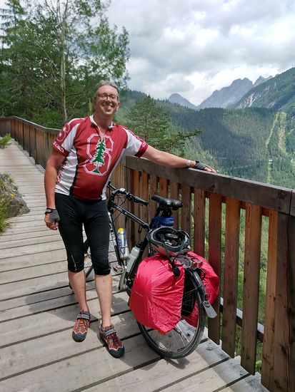Der geschotterte Radweg besteht auch teilweise aus einer langgezogenen, balkonähnlichen Konstruktion am Berghang, was das Vorankommen etwas erleichtert. Die Schotter-Teilstücke sind unter anderem derart unwegig und steil, daß man um ausgedehnte Schiebepartien, noch dazu mit meinem normalen Trekkingrad nicht herumkommt.
In der Verlängerung meiner linken Hand kann man übrigens in Form einer ansteigenden Zick-Zack.Linie einen Teil der Fernpaß-Bundesstraße erahnen.