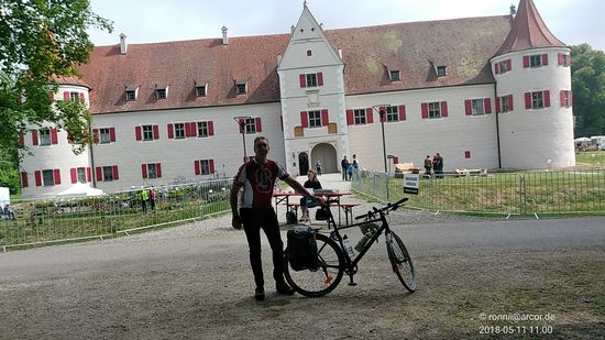 Der (abgeschattete) Herr am unteren rechten Eck des vorigen Bildes ließ es sich dabei nicht nehmen, mich abzulichten, wenn auch das Schloss etwas abgeschnitten und in Schräglage erscheint, da er selbst schon die Donau bis Wien abgeradelt hat und somit für die Zeit dieses kurzen Zwischenhalts ein interessanter Gesprächspartner war.
Vergrößert man dieses Bild mittels des Doppelpfeils am rechten oberen Bildrand, so kann man einigermaßen die Prospektverkäuferin an der Tischgarnitur hinter mir erkennen.
Vor Ort habe ich sie bzgl. der neuen Datenschutzgrundverordnung (DSGVO), die ab 25. Mai 2018 in Kraft tritt, darauf aufmerksam gemacht und vorsichtshalber um Erlaubnis gebeten, das Bild in meinem Internetreisebericht veröffentlichen zu dürfen, was sie auch bejahte - besonders gut kann man sie ja auch vergrößert nicht erkennen.
Mit diesen Zeilen möchte ich mit großem Unverständnis auf diese neue DSGVO verweisen, die momentan für viel Rechtsunsicherheit in Bezug auf (private) Fotografie in der Öffentlichkeit sorgt und von so manchem Fotografen als "Sargnagel" für diese bezeichnet wird.