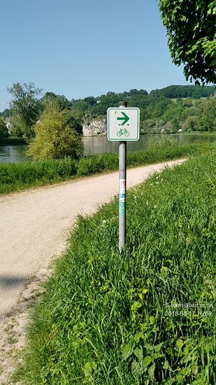 Bei Neustadt an der Donau wäre schon auf der großen Straßenbrücke ein Wechsel auf die Weltenburger Donauseite möglich gewesen, aber die Inanspruchnahme der Fähre von Hienheim nach Eining hatte da auf jeden Fall den nostalgischeren Charakter (nicht nur wegen den zufällig zur gleichen Zeit übersetzenden Steyr-Puch-Oldtimern, wie weiter oben beschrieben).
So ging es ab dem Eininger Fährufer wenige Kilometer auf einem Radler- und Wandererpfad direkt an der Donau entlang in Richtung Kloster Weltenburg. Hier im Bild kurz vor dem Kloster, das sich hinter dem oberen, linken Bildrand befindet, ist der Pfad schon wieder zu einem ausgebauten Radweg gewechselt.