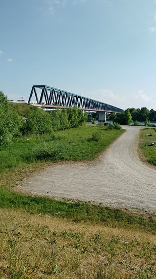 Auf dieser Stahlfachwerk-Eisenbahnbrücke gleich südlich von Deggendorf überqueren Züge in bzw. aus (von oben) Richtung Plattling die Donau.
Diese Brücke ist mit 466 m die längste Eisenbahnbrücke über die Donau, hat ein Gesamtgewicht von 3800 Tonnen und bietet eine Durchfahrtshöhe von 8 m für die Schifffahrt.