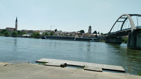 Gleich unterhalb der Marienbrücke stromabwärts bietet sich ein schöner Ausblick auf das Vilshofener Zentrum mit einem davor an der Donaulände angelegten Flußkreuzfahrtschiff.