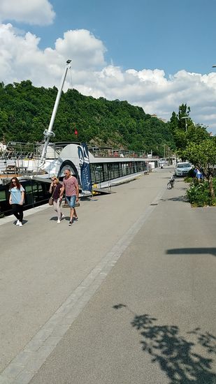 Entlang der Fritz-Schäffer-Promenade hatten mehrere Flußkreuzfahrtschiffe angelegt, um ihren Passagieren Landgang zu gewähren.
Jedoch lästern auch viele Passauer über die "einfallenden" Touristen.
Über diesen Fluch und/oder Segen, der auch in Regensburg, Bamberg und anderen Touristen-Mekkas existiert, gibt es einen ausführlichen Zeitungsbericht vom 22.1.2018 in der Süddeutschen Zeitung:
"Passau wird zur Pappkulisse"
Wer sich dafür interessiert, kann ihn sich unter folgendem Link verinnerlichen:
"Passau wird zur Pappkulisse"
Also ich habe von den durchschnittlichen 
28 € der Kreuzfahrer im Bericht keine 5 € in Form von zwei Eis am Stiel im Hauptbahnhof in der Stadt gelassen, geschweige denn einen Oktoberfesthut gekauft, dafür aber auch nicht die Innenstadt verstopft, die ich außen bzw. innen vor ließ.