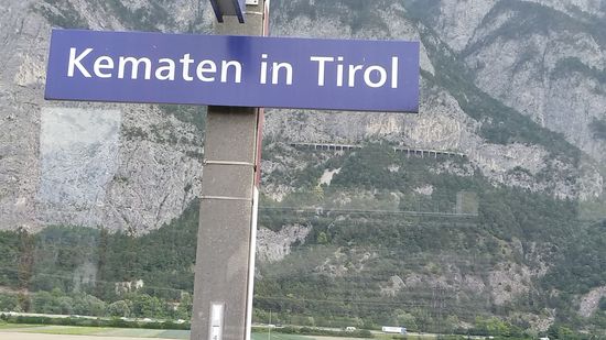 Vom Bahnhof in Kematen aus sieht man die abenteuerlich in die Felswand gebaute Schutzgalerie (unterhalb von "Tirol" auf dem Stationsschild) der Bahnstrecke von Innsbruck nach München über Garmisch-Partenkirchen.