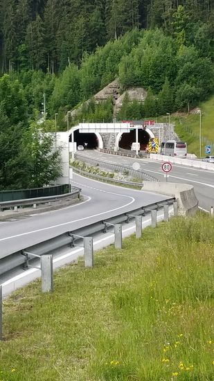 Ein kurzer Blick auf die Tunnelröhren der nach St. Anton am Arlberg und weiter nach Bludenz und Feldkirch im Bundesland Vorarlberg führenden Schnellstraße S 16, die für mich als Radler natürlich tabu war. 
Für mich galt ja die hier in einer Linkskurve verlaufende, ab hier B 316 genannte Bundesstraße.
Ergänzend will ich noch sagen, daß "meine" B 316 als schwach befahren gilt, da der Großteil des Verkehrs ja von der Schnellstraße aufgenommen wird.
Als ich letztes Jahr auf der Silvretta-Strecke unterwegs war, war die Schnellstraße wegen längerer Tunnelarbeiten gesperrt, so daß der Fernverkehr nach Vorarlberg über den Arlbergpass umgeleitet wurde. 
Da war dann die Bundesstraße für Radfahrer gesperrt.