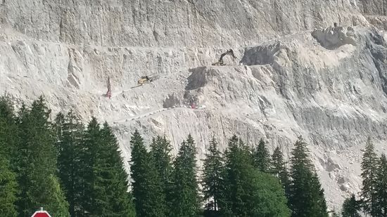 Dieses Bild zeigt den unteren Bereich des oberen Bildes und wenn man in Bildmitte den die steile Rampe abfahrenden großen Muldenkipper, sowie rechts oberhalb davon den steinbrechenden Bagger erblickt, ahnt man erst so recht die Dimensionen dieser Arbeitsstätte.
Beim kurzzeitigen Verfolgen dieser Szenen bemerkte ich anhand meines Schaudergefühls, daß dies nicht mein Job wäre...