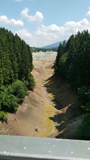 Am nordwestlichen Ende des Forggensees schweift der Blick von der 
B16-Straßenbrücke über das Tiefental, in dem der Bernmoosbach zum Forggensee führt, der im Hintergrund als leichte "Pfütze" erkennbar ist.