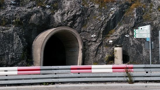 Nach Ende der Pause an der Brücke gelangt man nach kurzer Strecke an die Staumauer, vor der die hier beginnende B 13 nach links in Richtung Bad Tölz abzweigt. Für Radfahrer auf dem Isarradweg gibt es dabei die Wegführung über die Staumauer und kurz danach linkerhand durch einen kurzen, beleuchteten Tunnel, den Beginn des Toni-Seber-Wegs, der dann etwas später neben der B 13 bis Lenggries und ab dort dann weiter an der Isar nach Bad Tölz führt.