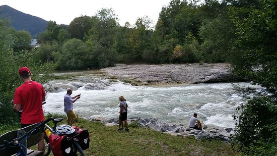 Ausflügler genießen bei einer kurzen Pause gleich nördlich von Lenggries die hier einen kleinen Abfall rauschend passierende Isar.