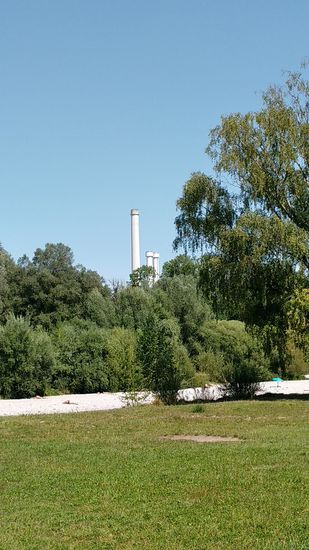 Im Hintergrund erscheinen die Kamine des Heizkraftwerks (HKW) Süd in 
München-Sendling, das zur Fernwärmeerzeugung dient.