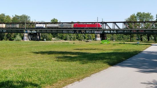 Die im Süden der Münchner Innenstadt gelegene 1871 fertiggestellte Braunauer Eisenbahnbrücke, die mit gut 150 m Länge als Teil des Südrings den Ostbahnhof mit dem Hauptbahnhof München verbindet.
Einwurf vom Hobby-Eisenbahner auf Radtour  :
Hier wird gerade ein Güterzug mit einer Siemens-Hochleistungslok der neuesten Generation vom Typ Vectron, Baureihe 193, je nach Ausführung bis zu 6400 kW Leistung, in Richtung Ostbahnhof und weiter in Richtung Rosenheim und Salzburg oder auch Brenner befahren.