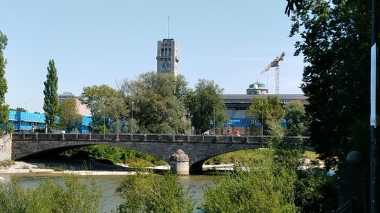 Kurz nach der Reichenbachbrücke erscheint am südlichen Ende der Museumsinsel, auf der sich das Deutsche Museum befindet, die Corneliusbrücke, von der es auch einen Zugang zur Insel gibt.
Drei Bögen mit einer gesamten lichten Weite von 121 m überspannen dabei den Haupt- und Nebenarm der Isar.
Da 1902 der östliche der beiden kleineren Bögen (hier im Bild der rechte) bei den Bauarbeiten kurz vor seiner Fertigstellung einstürzte und zwei tote, sowie mehrere verletzte Arbeiter forderte, wurde sie Anfang Oktober 1903 ohne Feierlichkeiten eröffnet.