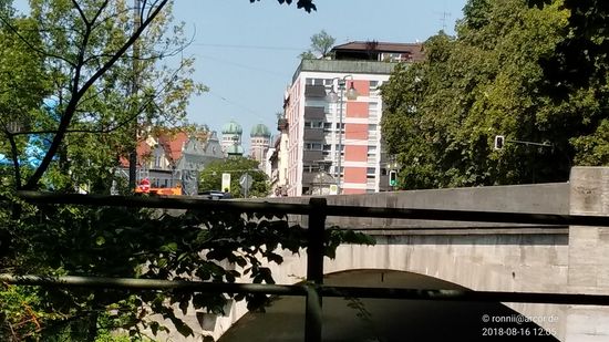 Von der Kleinen Isar aus erblickt man im Hintergrund die beiden Türme der Frauenkirche, für deren Bau von 1473-1475 7000 Holzstämme aus den Isarwinkler Bergen mit 147 Flößen auf der Isar in die Residenzstadt befördert wurden. 
Ab Mittenwald dauerte dabei die Fahrt bis München ca. 12 Stunden.