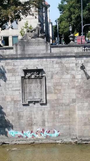 Linkerhand der Luitpoldbrücke befindet sich auf der Westseite der Isar an der Ufermauer eine Dankesinschrift:
Luitpold
Prinzregent
von Bayern
liess
diese Brücke
erbauen